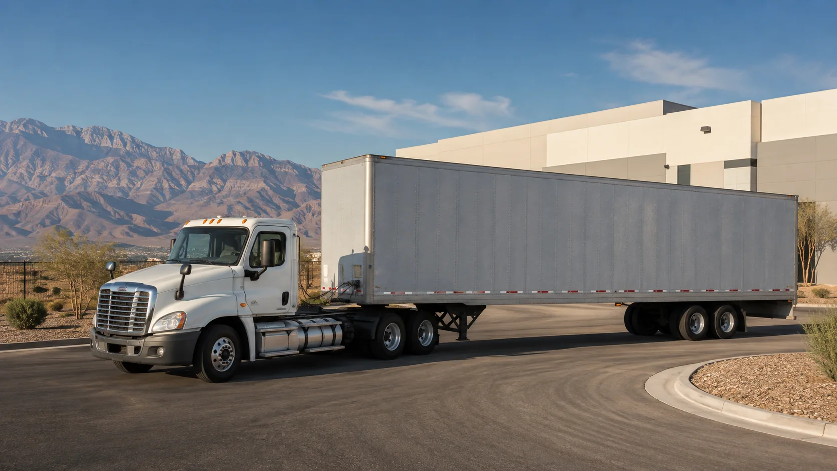 Unbranded tractor and dry-van trailer approaching a Las Vegas industrial warehouse